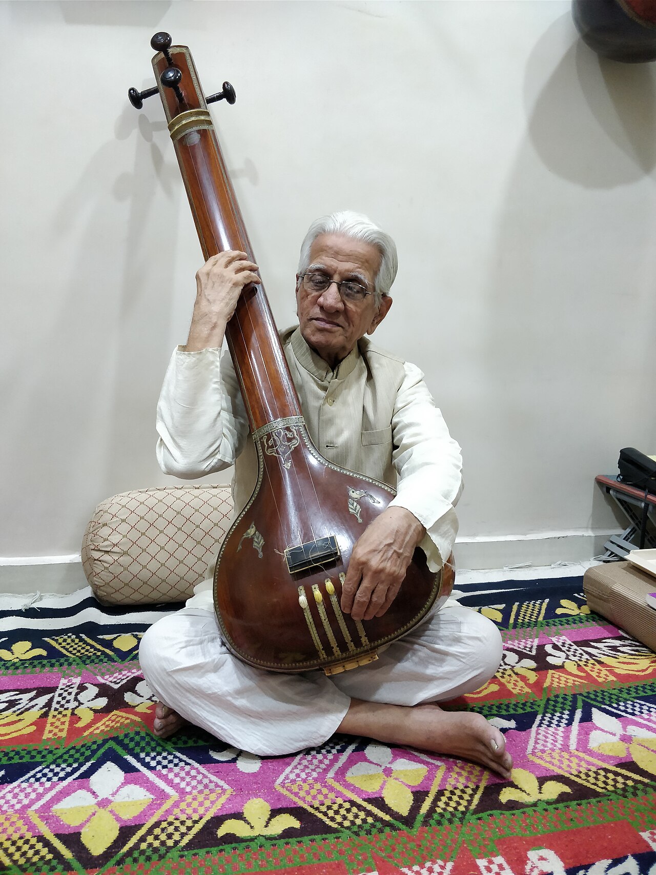 तानपुरा लिए एक हिंदुस्तानी गायक — वह वाद्य जो ख़याल प्रदर्शन में सुरों की नींव रखता है, जिसके भीतर तान के तेज़ मार्ग गाए जाते हैं