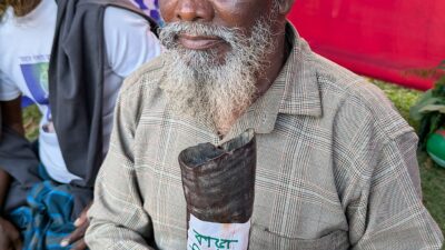 एक संताल व्यक्ति अपनी पारंपरिक बाँस की बाँसुरी थामे हुए — तिरियो इसी संताल बाँसुरी-परिवार का वाद्य है